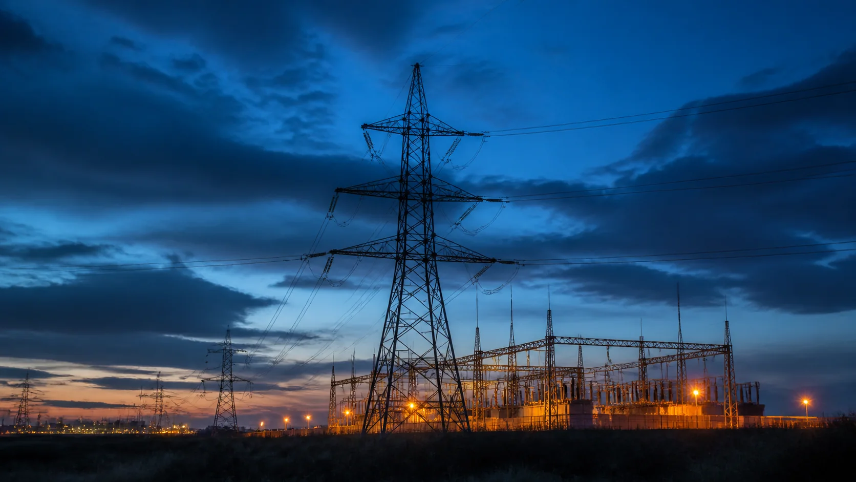 High-voltage transmission grid and substation at blue hour